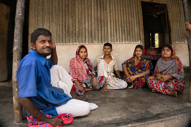 Rezaul è il penultimo di una famiglia di sette figli. Suo padre, Mohammad Jamal Sheikh (sinistra), 48 anni, guida il suo rickshaw e sua madre, Mazu Begum, 40 anni, è casalinga (seconda a destra). Le sorelle maggiori, Ruma Begum (l’ultima a destra) e Jamirun Begum (seconda da sinistra), vivono con i mariti ma sono spesso ospiti nella casa dei genitori. Il fratello minore di Rezaul, Billal Sheikh (centro) e la sorella maggiore Rojina convivono con Rezaul e i genitori.